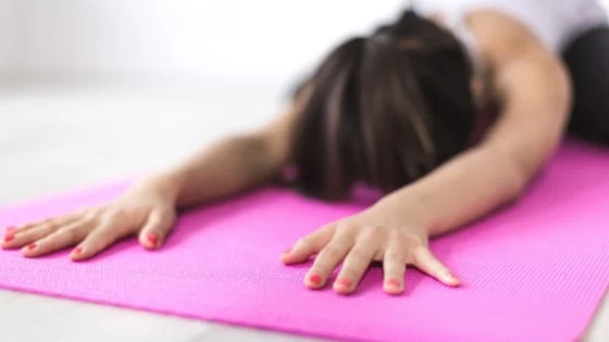 A woman stretching on a pink exercise mat