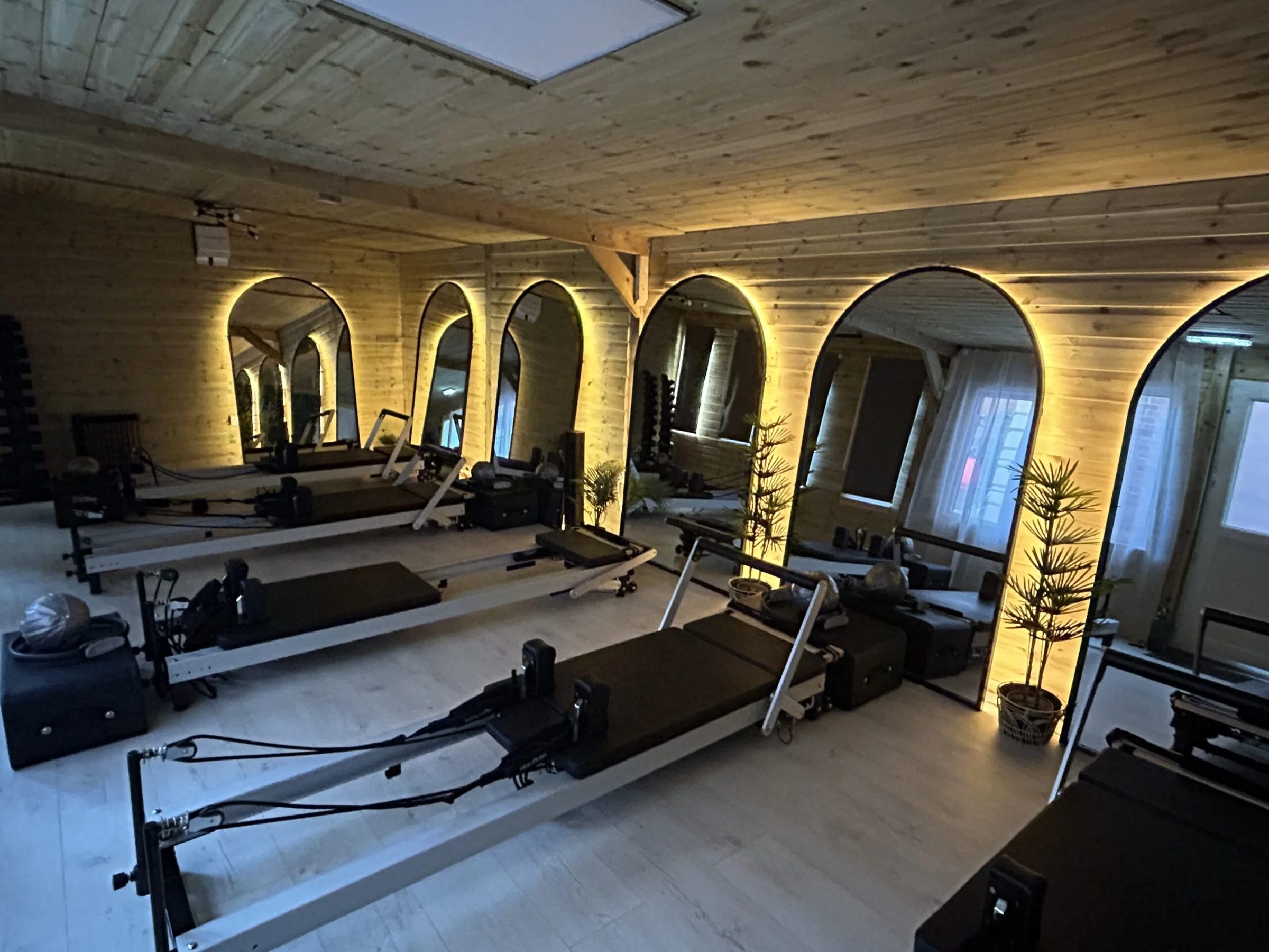 The Flow Reformer Pilates studio at Masters Fitness, with reformer machines in front of softly lit arched mirrors