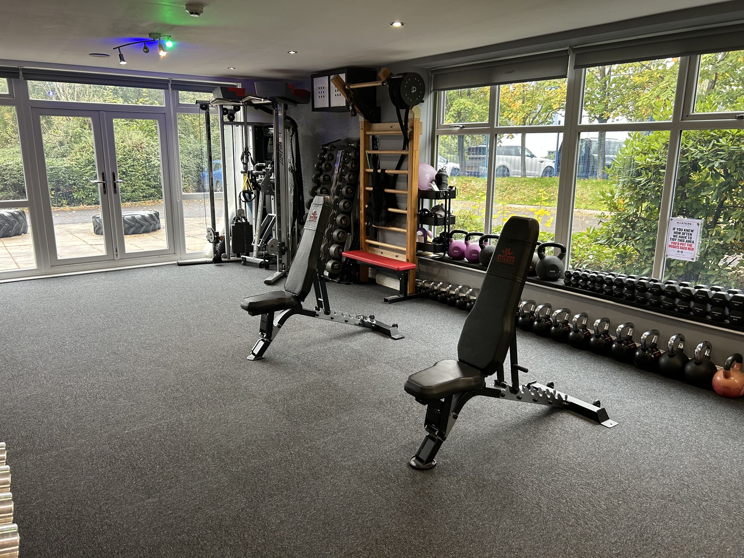 The upstairs training floor with adjustable benches, racks and kettlebells