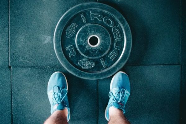 Looking down at trainers beside a weight plate on the floor