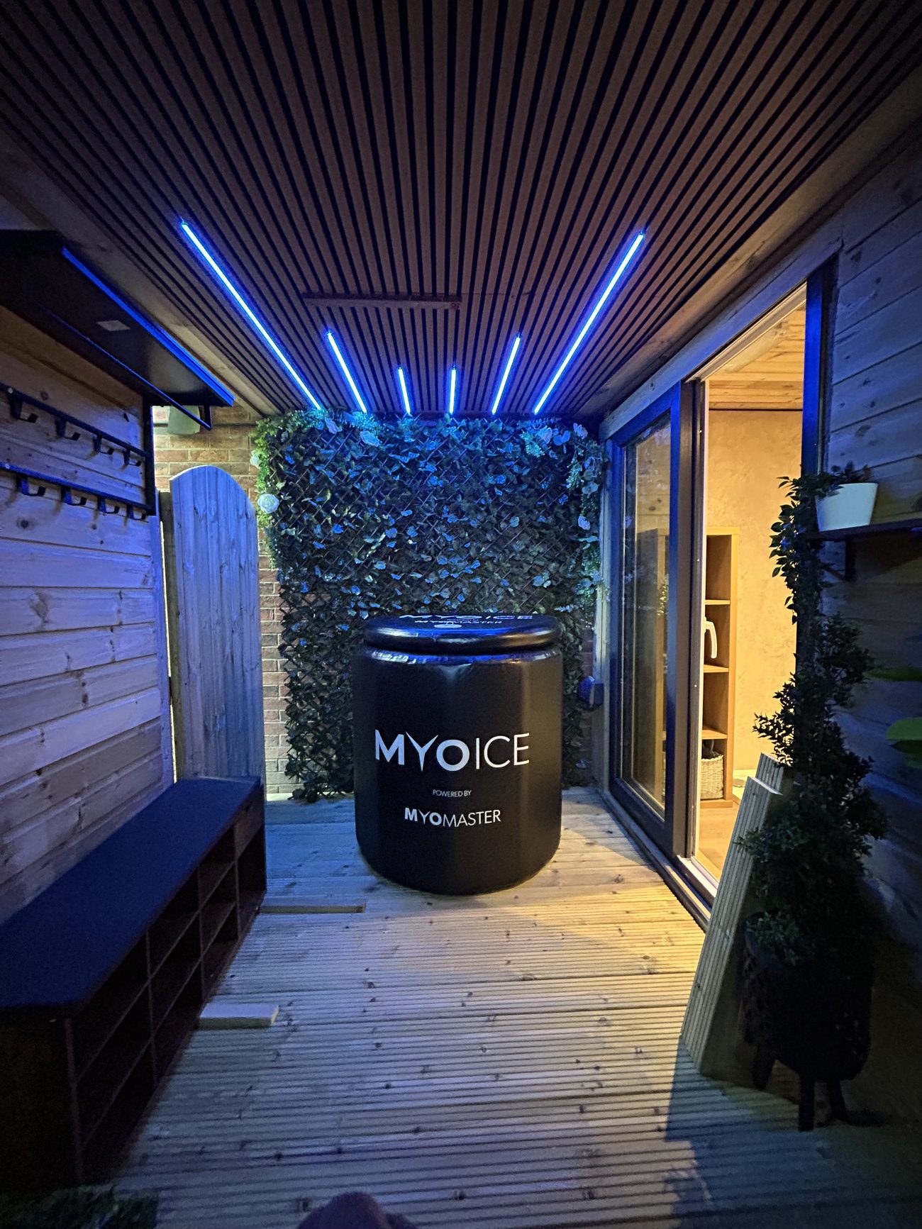 The Recovery Zone lodge corridor, with blue ceiling lights, a living green wall and the MyoIce cold plunge