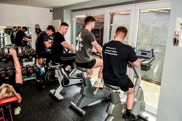 Members training on the cardio and weights floor