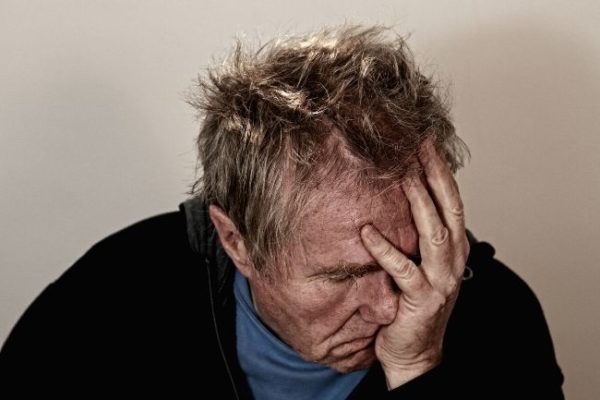 A man holding his head, feeling unwell