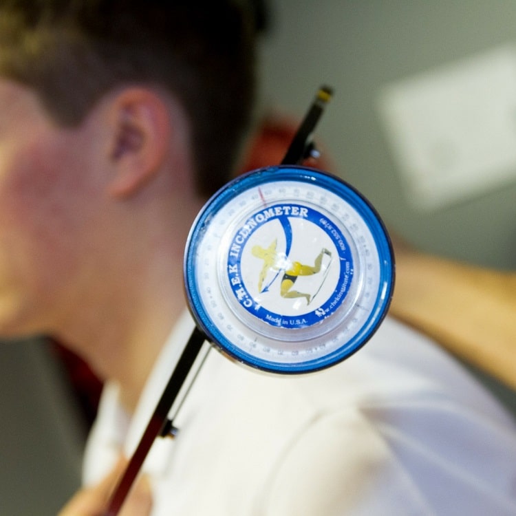 A C.H.E.K inclinometer held against a client's shoulder