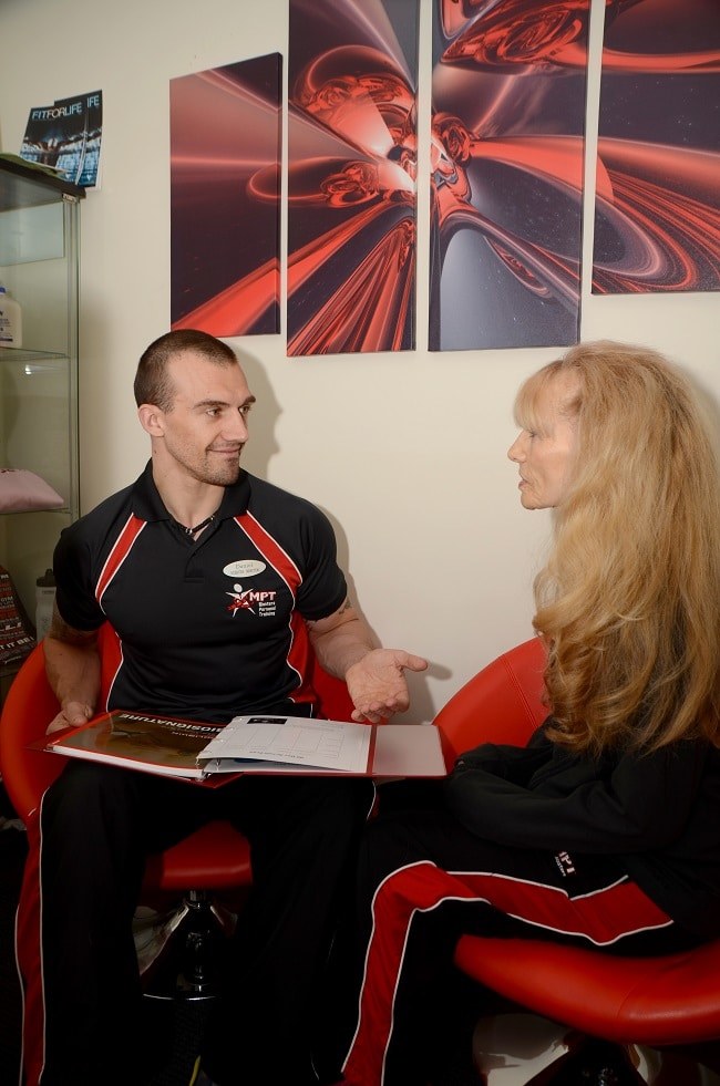 A Masters Fitness coach talking through an assessment with a client in the consultation room