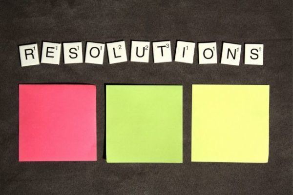 The word resolutions spelled out above three sticky notes