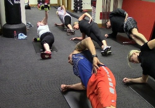 A class doing side planks on mats