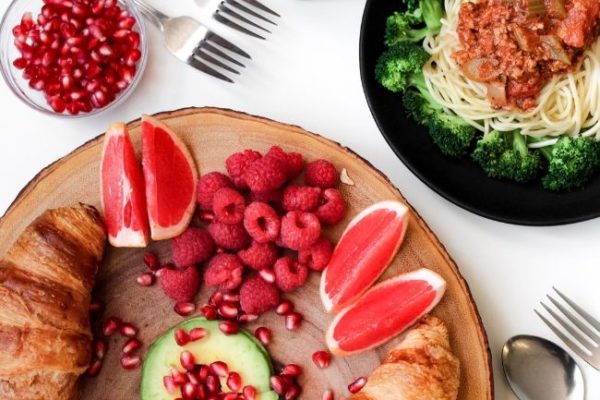 A table of fruit, pastries and pasta