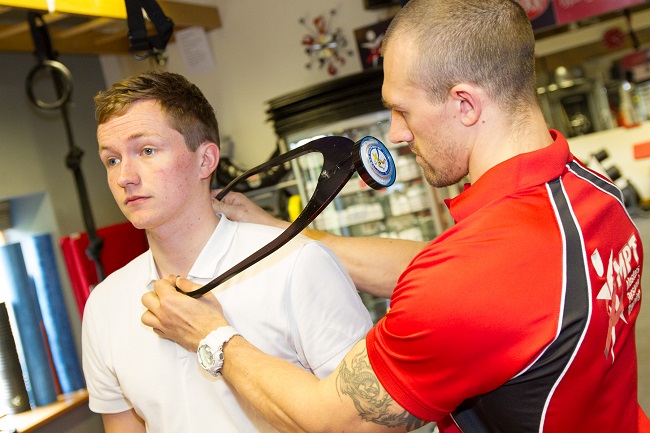 A Masters Fitness coach measuring a client's posture with an inclinometer
