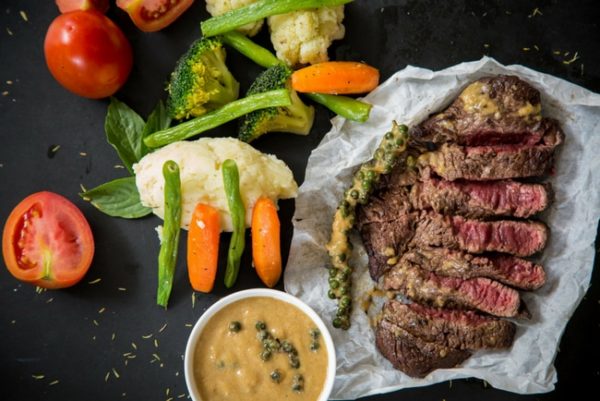 A steak with vegetables and sauce