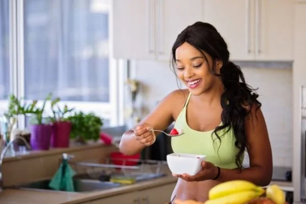 A woman eating a healthy breakfast in her kitchen