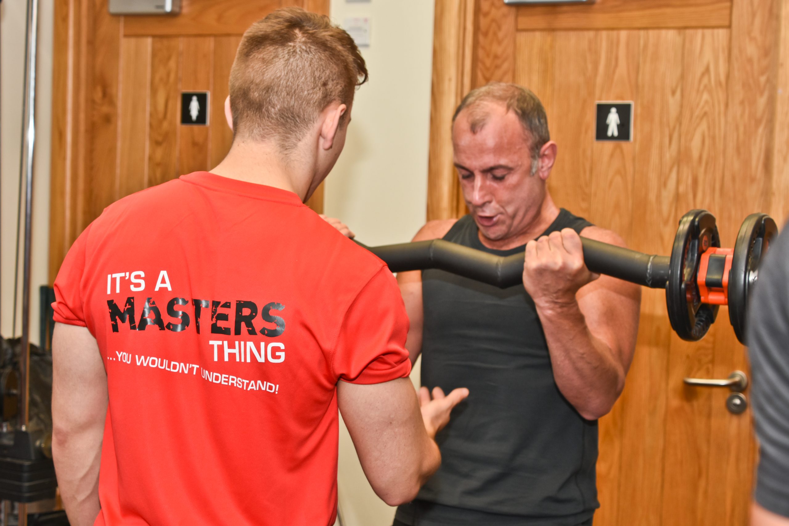 A Masters Fitness personal trainer coaching a client through a bicep curl