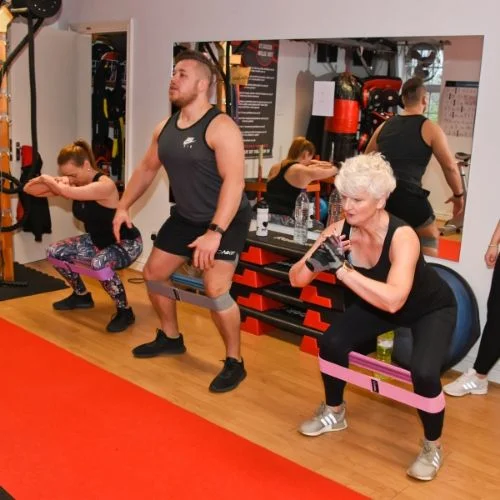 A class doing banded squats