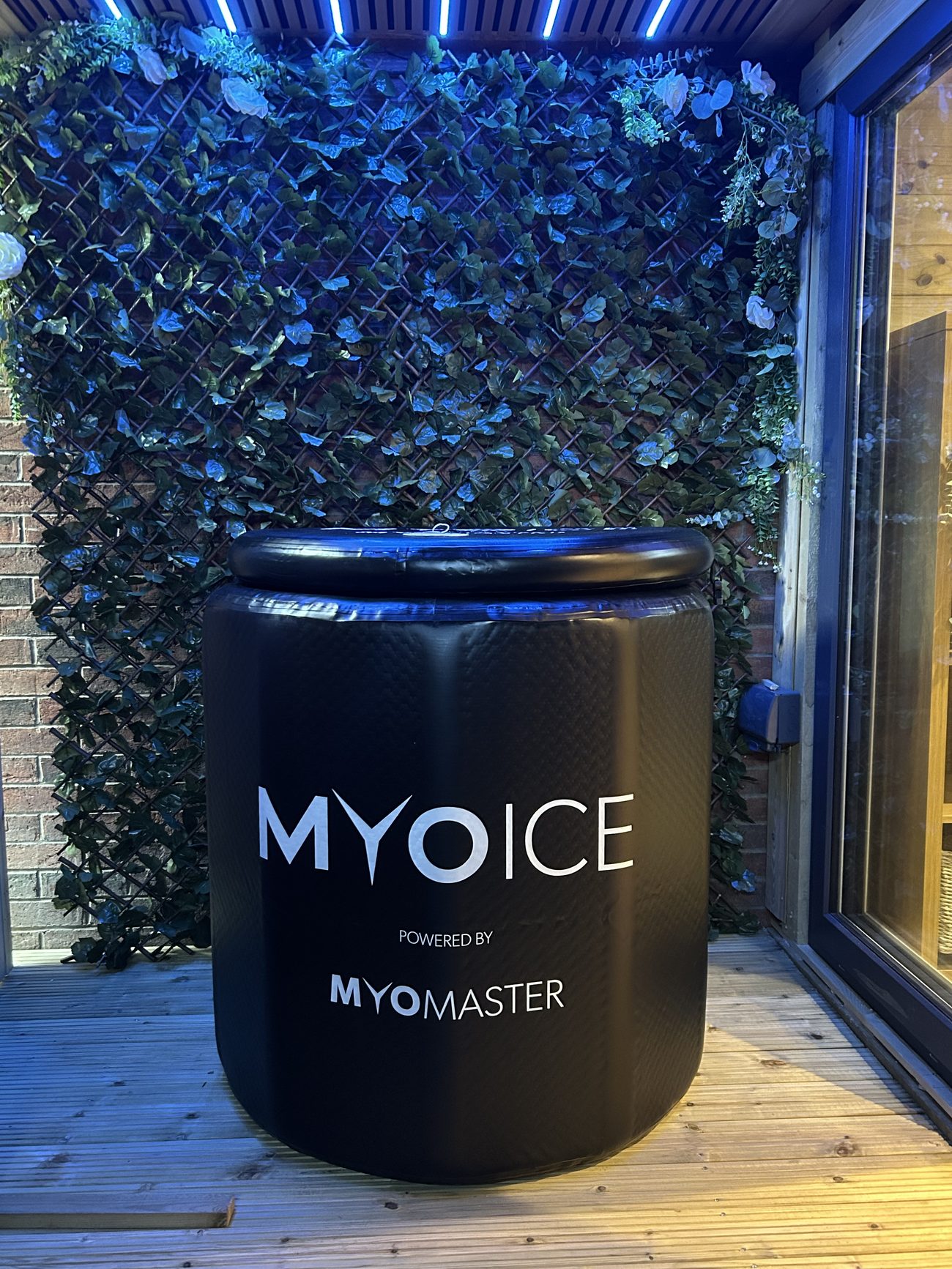 The MyoIce cold plunge by MyoMaster in front of the green wall